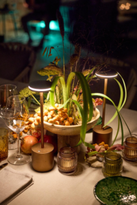 Evening table setting with portable lamps, pomegranates and amber glassware