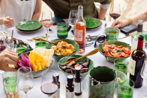 Green ceramic bowls with roasted vegetables and rosé wine, relaxed private lunch styling